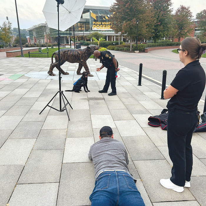 Photographer lying on the sidewalk to take a photo of Bruno